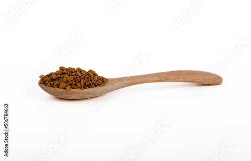Instant coffee on wooden spoon isolated on white background. Instant coffee is a beverage derived from brewed coffee beans that enables people to quickly prepare hot coffee.
