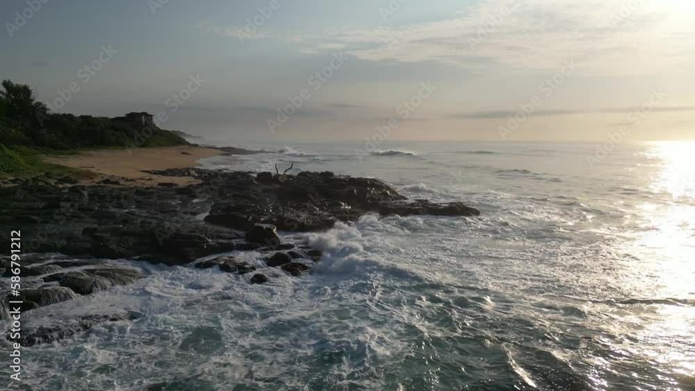 rising up looking at waves and sea foam crashing against the rocks at sunrise over the Indian Ocean from Durban South Africa. rising up looking at waves and sea foam crashing against the rocks at sunrise over the Indian Ocean from Durban South Africa.