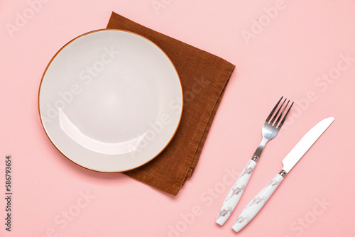Table setting with napkin on pink background