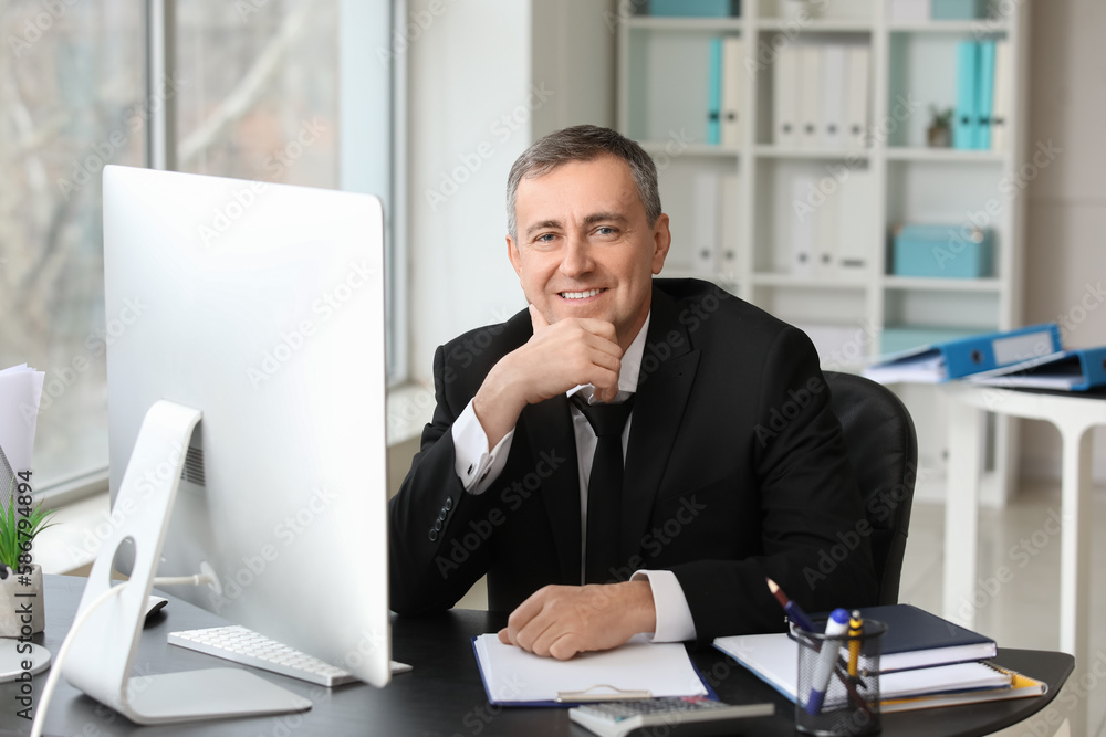 Mature accountant working at table in office Mature accountant working at table in office