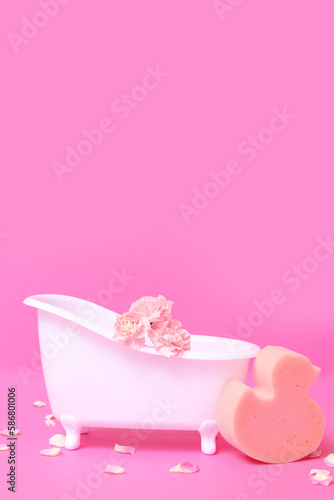 Fototapeta Naklejka Na Ścianę i Meble -  Small bathtub with carnation flowers and sponge on color background
