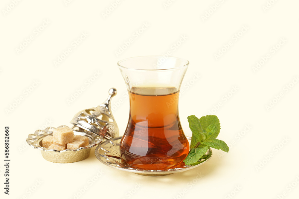 Glass cup of Turkish tea with mint on beige background Glass cup of Turkish tea with mint on beige background