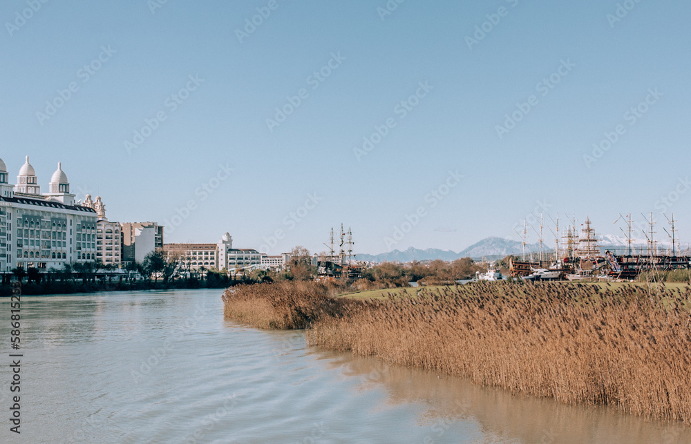 Ship graveyard in Turkey on river with dry grass on the sides