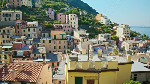 Colorful stone houses stacked on top of one another with a harbor filled with traditional fishing boats in Riomaggiore.
The most southern village of the five Cinque Terre with a small beach and a whar photo