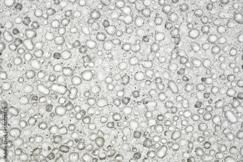 Pumice porous gray structure close-up with bubbles frozen, background wallpaper, uniform texture pattern