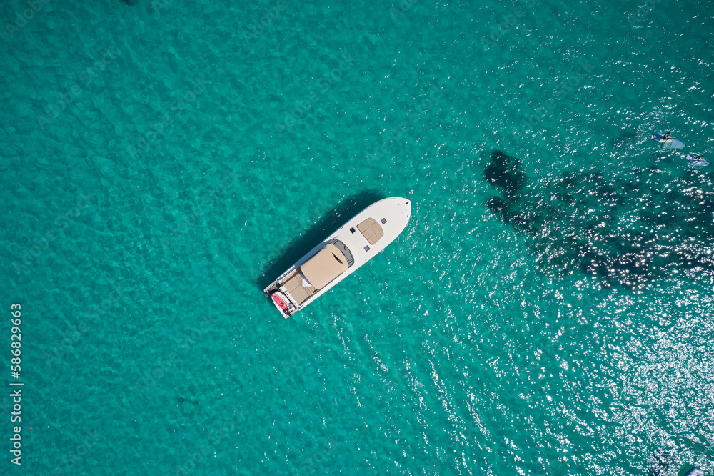 Large motor white boat with an awning parking on the turquoise water top view. Large motor white boat with an awning parking on the turquoise water top view.