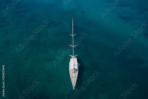 White sailing yacht anchored on turquoise water top view. © Berg