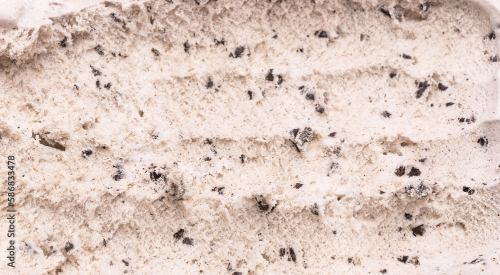 Close-up of Cookies and Cream flavored ice cream being scooped into grooves by a steel spoon. Close-up of Cookies and Cream flavored ice cream being scooped into grooves by a steel spoon.