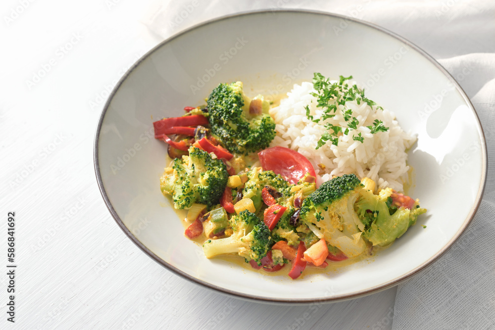 Vegetable dish from broccoli, leek and tomato served with rice and parsley garnish on a light gray plate, healthy vegetarian meal, copy space, selected focus Vegetable dish from broccoli, leek and tomato served with rice and parsley garnish on a light gray plate, healthy vegetarian meal, copy space, selected focus