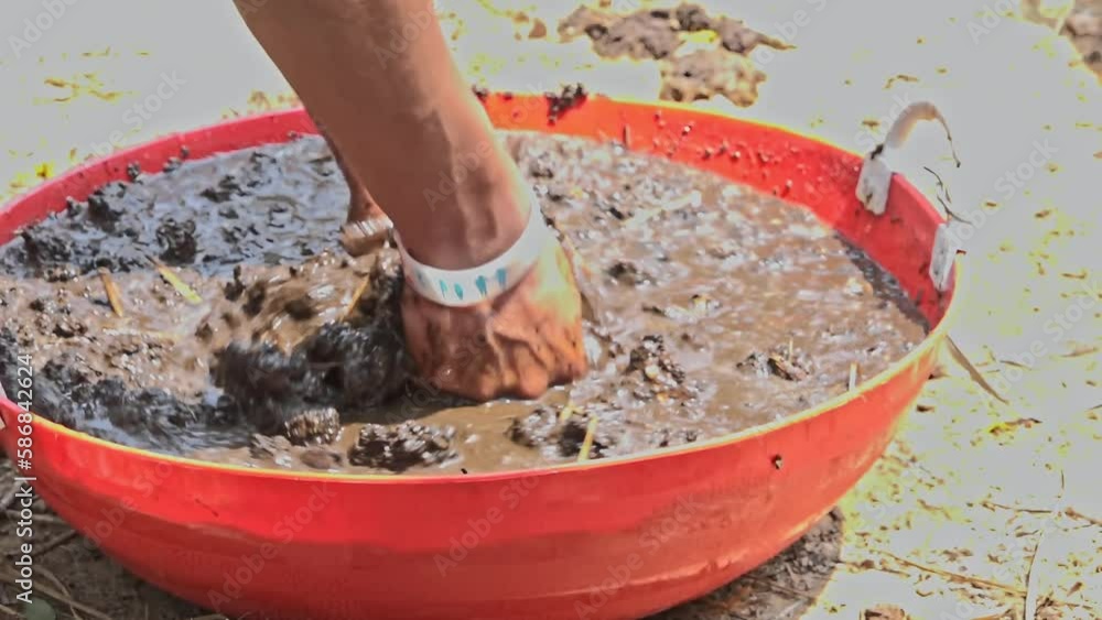 Closeup of bare hands mixing fertile soil and compost with water Closeup of bare hands mixing fertile soil and compost with water