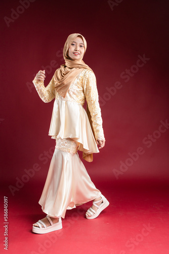 Young smiling confident asian muslim woman in hijab over isolated over background studio. Casual hijab fashion. © Azfar.arts