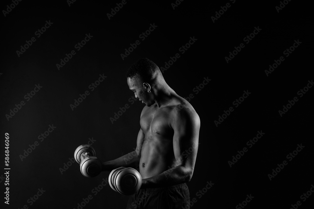Portrait of a happy african man with dumbbells over red and black background Portrait of a happy african man with dumbbells over red and black background