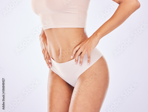 Woman, body and stomach for healthy lifestyle in studio as motivation for weight loss, diet or fitness. Female on a white background with hand on waist for health, wellness or skin care in underwear photo