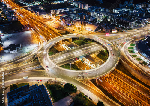A illuminated multilevel highway junction interchange during night time with blurred car traffic as seen in Athens, Greece