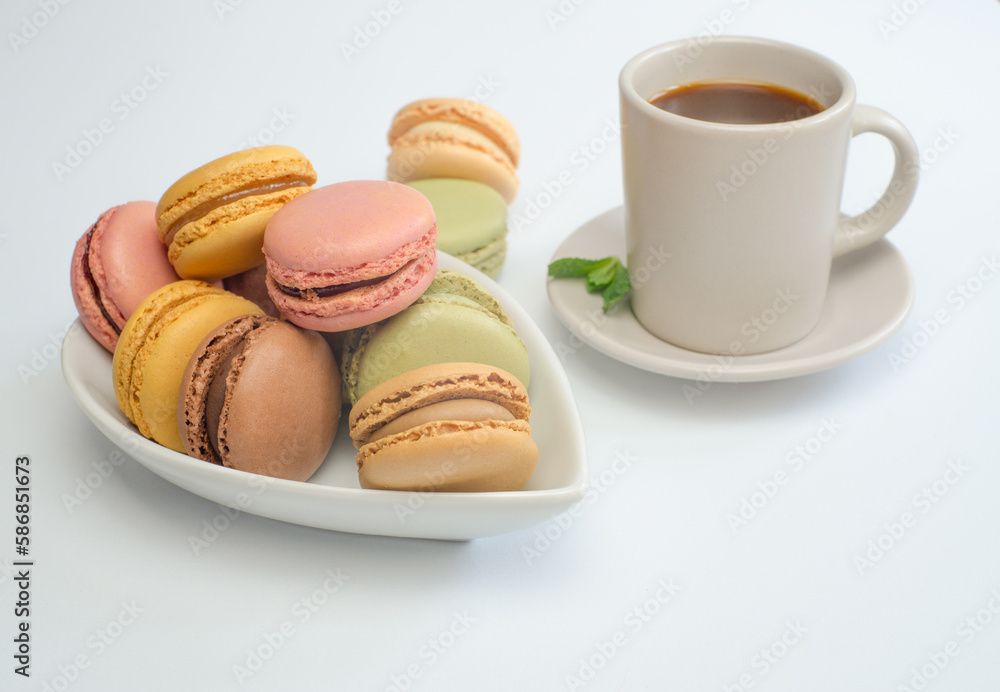 colorful macaroons on white tray with coffee cup and mint leaves isolated on white background and copy space colorful macaroons on white tray with coffee cup and mint leaves isolated on white background and copy space