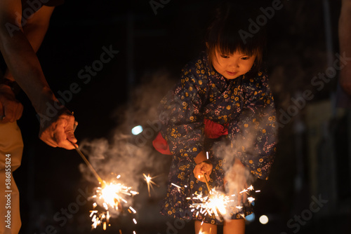 夏休みに帰省しておじいちゃんと花火をする子供 photo