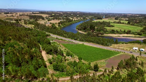 Green landscapes of the Malleco valley in Southern Chile. Cinematic drone flight beside unique river system feeding the neighbouring vineyards. photo