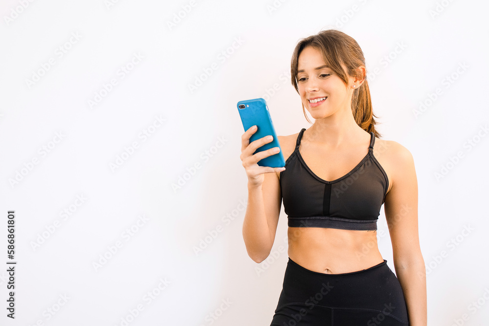 Young Sporty Woman Using Exercise App to Workout at Home Young Sporty Woman Using Exercise App to Workout at Home