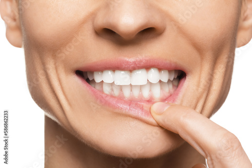 Woman showing healthy gums on white background, closeup