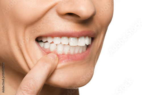 Woman showing healthy gums on white background  closeup