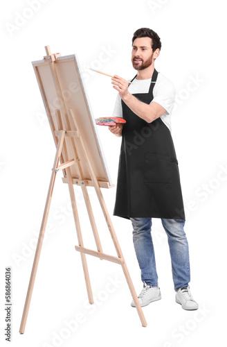 Artist with brush painting against white background. Using easel to hold canvas