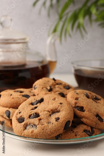 Delicious chocolate chip cookies and tea on white marble table