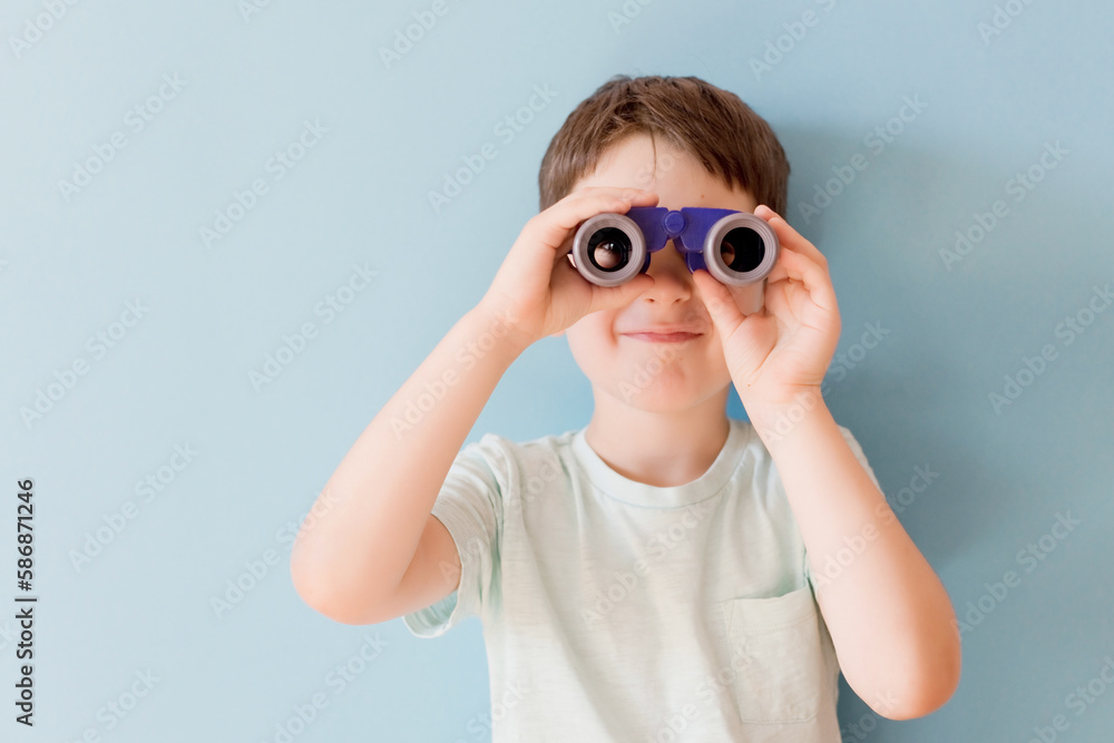 Child with binoculars on blue background Child with binoculars on blue background