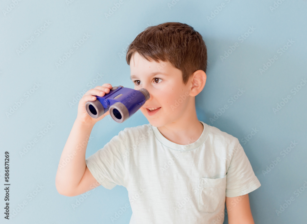 Child with binoculars on blue background Child with binoculars on blue background