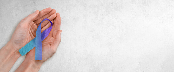 Teal and Purple Ribbon in Woman's Hands, Suicide Prevention Awareness Concept with Copy Space