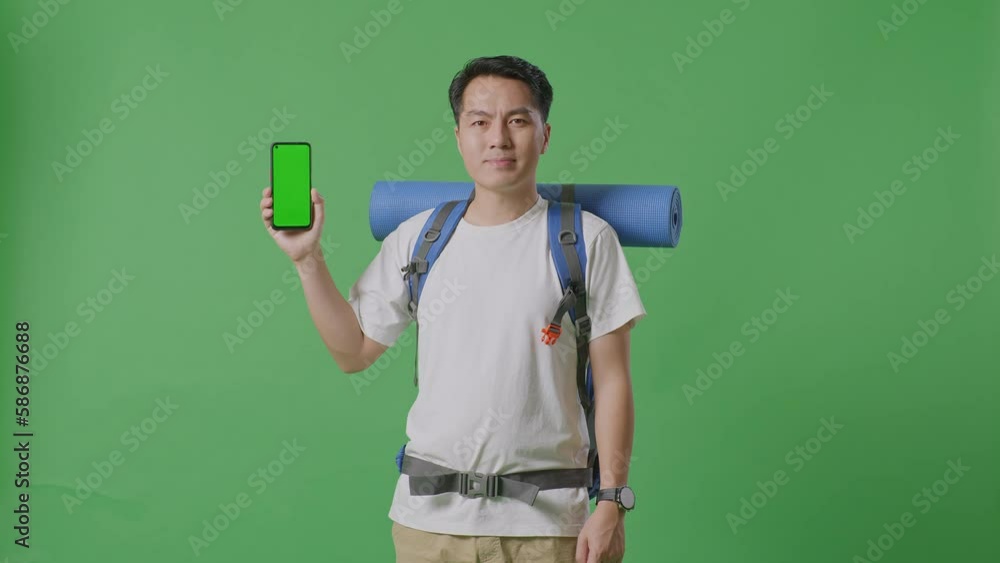 Asian Male Hiker With Mountaineering Backpack Smiling And Showing Mock Up Green Screen Smartphone While Standing On Green Screen Background In The Studio
Asian Male Hiker With Mountaineering Backpack Smiling And Showing Mock Up Green Screen Smartphone While Standing On Green Screen Background In The Studio