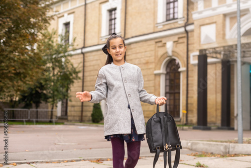 Preteen girl child with backpack outdoors. Pretty schoolgirl going home after class
