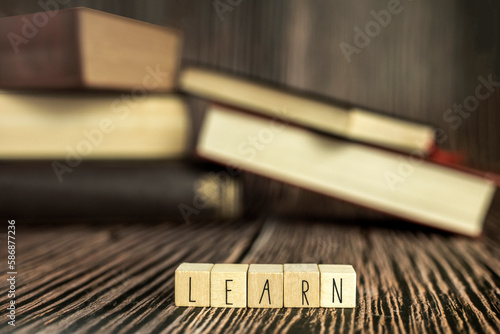 Pile of books, reading. Stack of books in the colored cover lay on the table. Open book with the text learn wooden background, education, reading, learning concept