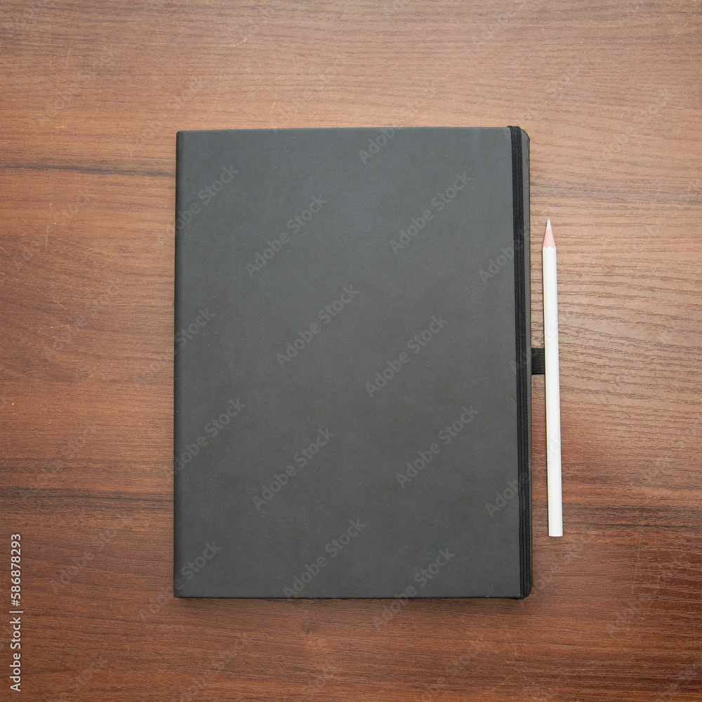 Fototapeta premium Notebook and pencil on a beautiful background in a photo studio