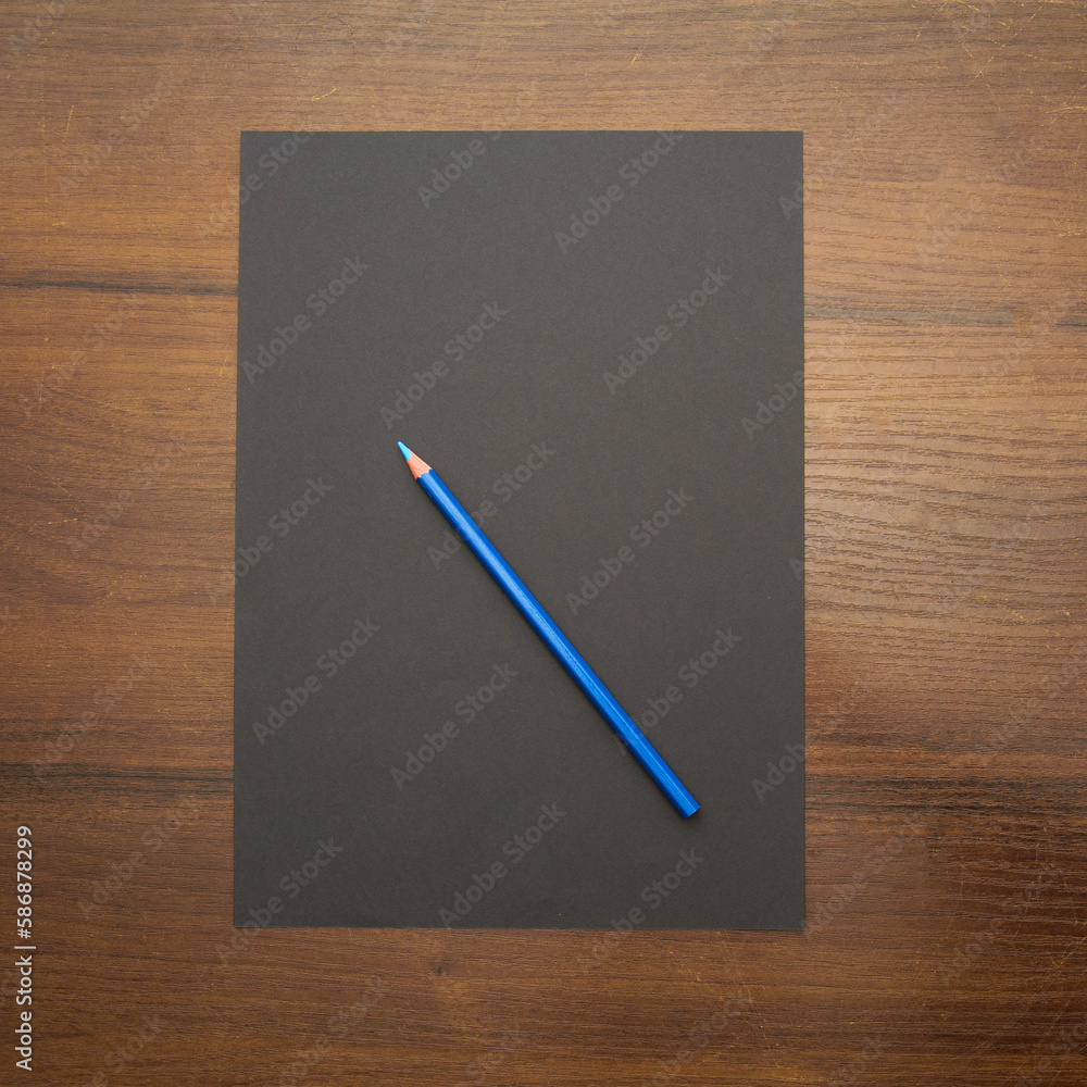 A pencil lies on a blank sheet of paper on a beautiful background in a photo studio A pencil lies on a blank sheet of paper on a beautiful background in a photo studio