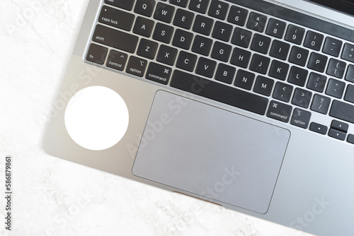 Round Sticker Mockup on Modern Silver Laptop atop Marble Background