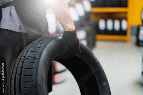 A mechanic holding a tire in a tire warehouse of a car service center