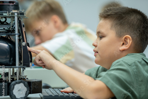 Boy male teen child concentrate enjoy Machine Learning Robot is Moving Under Control robot coding at technology stem class, stem education robot for digital automation artificial intelligence ai