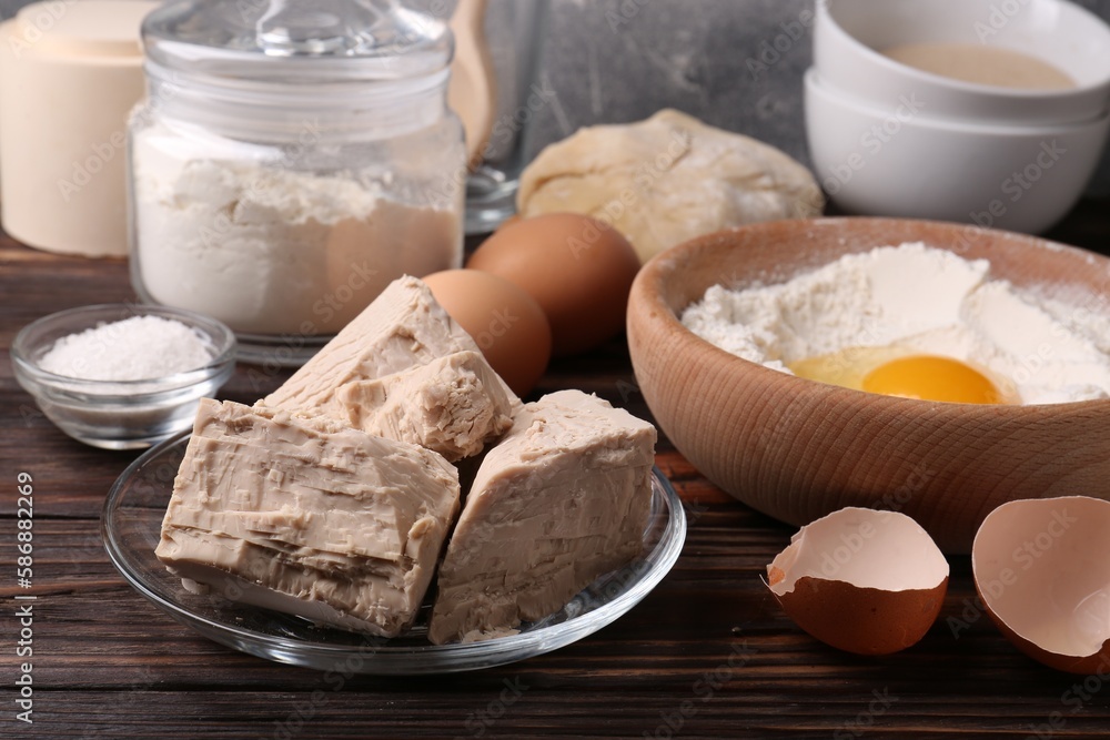 Compressed yeast, flour, salt, dough and eggs on wooden table Compressed yeast, flour, salt, dough and eggs on wooden table