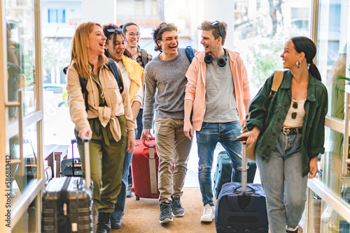 Group of university college tourist walking inside the hotel with suitcases -Young happy students enjoying summer holiday-Tourism Vacation and Lifestyle concept with people-Youth culture-Spring time  photo