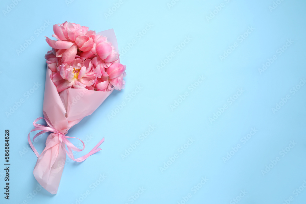 Beautiful bouquet of pink peonies on light turquoise background, top view. Space for text