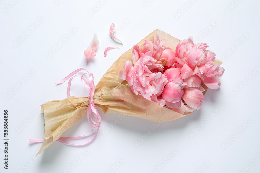 Beautiful bouquet of pink peonies wrapped in paper on white background, top view Beautiful bouquet of pink peonies wrapped in paper on white background, top view