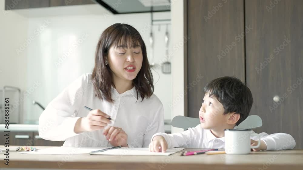 部屋で鉛筆とノートを使って勉強する親子