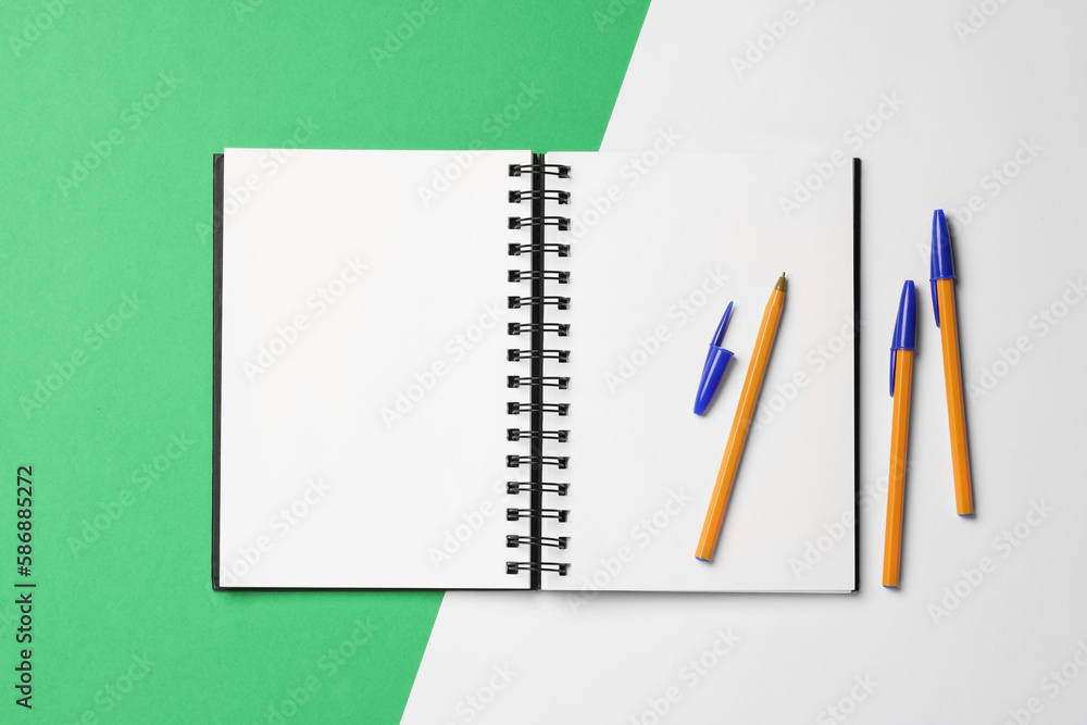 Ballpoint pens and notebook on color background, flat lay Ballpoint pens and notebook on color background, flat lay