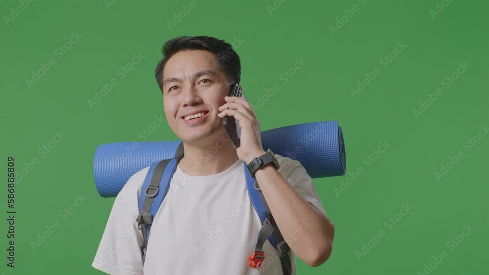 Close Up Of Asian Male Hiker With Mountaineering Backpack Smiling And Talking On Smartphone While Standing On Green Screen Background In The Studio
Close Up Of Asian Male Hiker With Mountaineering Backpack Smiling And Talking On Smartphone While Standing On Green Screen Background In The Studio