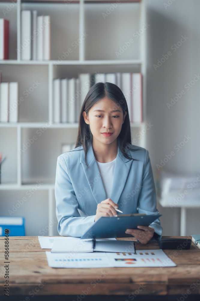 Asian businesswoman talking on phone, using laptop, looking at screen, entrepreneur manager consulting client by call, looking at computer screen, discussing Asian businesswoman talking on phone, using laptop, looking at screen, entrepreneur manager consulting client by call, looking at computer screen, discussing