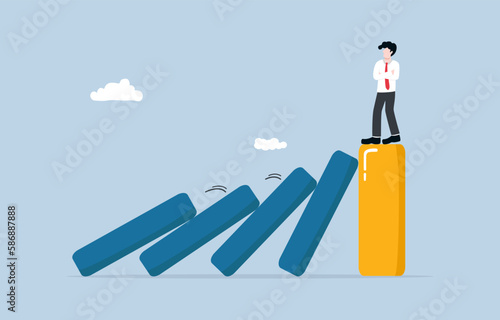 strong business during recession, well prepared management against negative economic impact, surviving company concept, Businessman standing on strong bar graph unaffected by domino effect. 