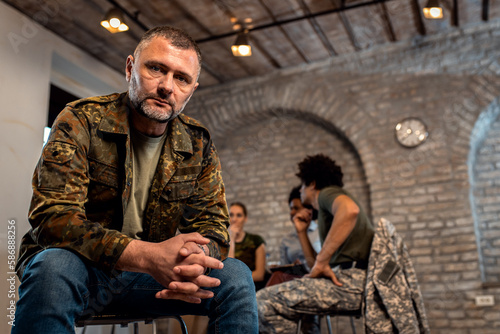 Portrait of male veteran in PTSD support group looking at camera.