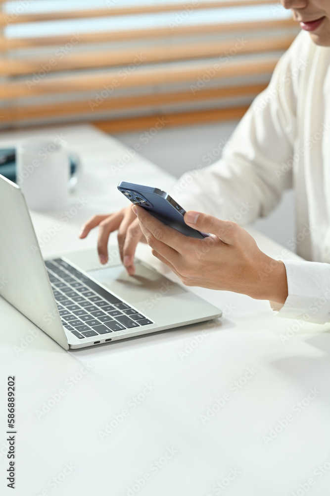 Fototapeta premium Cropped shot young businessman in white shirt texting messages, chatting in social on smartphone