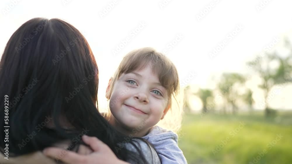 Happy family. Mom and daughter walk in the summer park. The daughter holds her mother's hand. Maternal support. Family picnic in the park on green grass in spring. Family walk in nature in the park Happy family. Mom and daughter walk in the summer park. The daughter holds her mother's hand. Maternal support. Family picnic in the park on green grass in spring. Family walk in nature in the park
