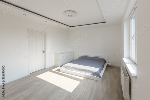 Single wooden bed and blanket next to stylish wooden cabinet in elegant bedroom.